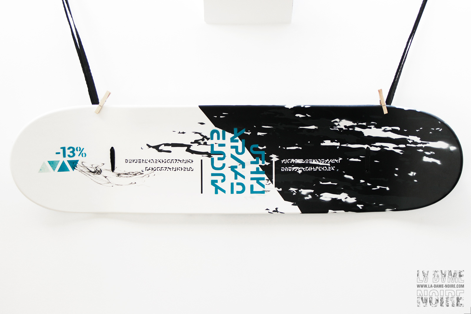 Face arrière d'un Skateboard peint en noir et blanc avec éléments graphiques bleu