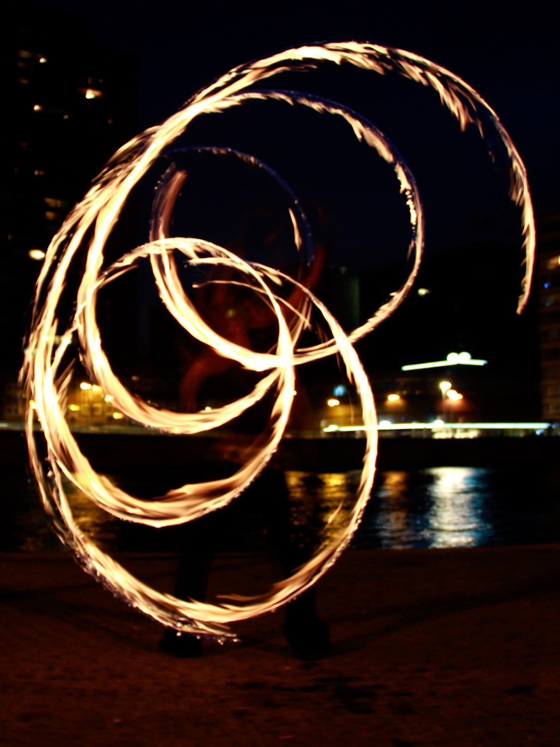 Photo nocture des trainées de feu provoquées par un fire staff