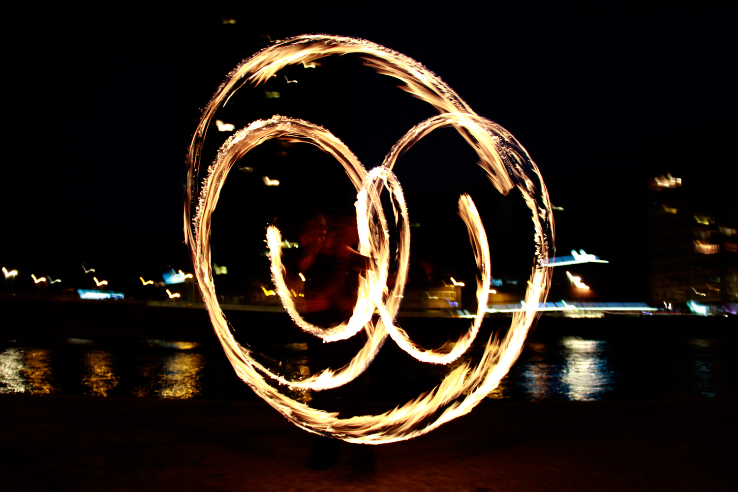 Photo nocture des trainées de feu provoquées par un fire staff