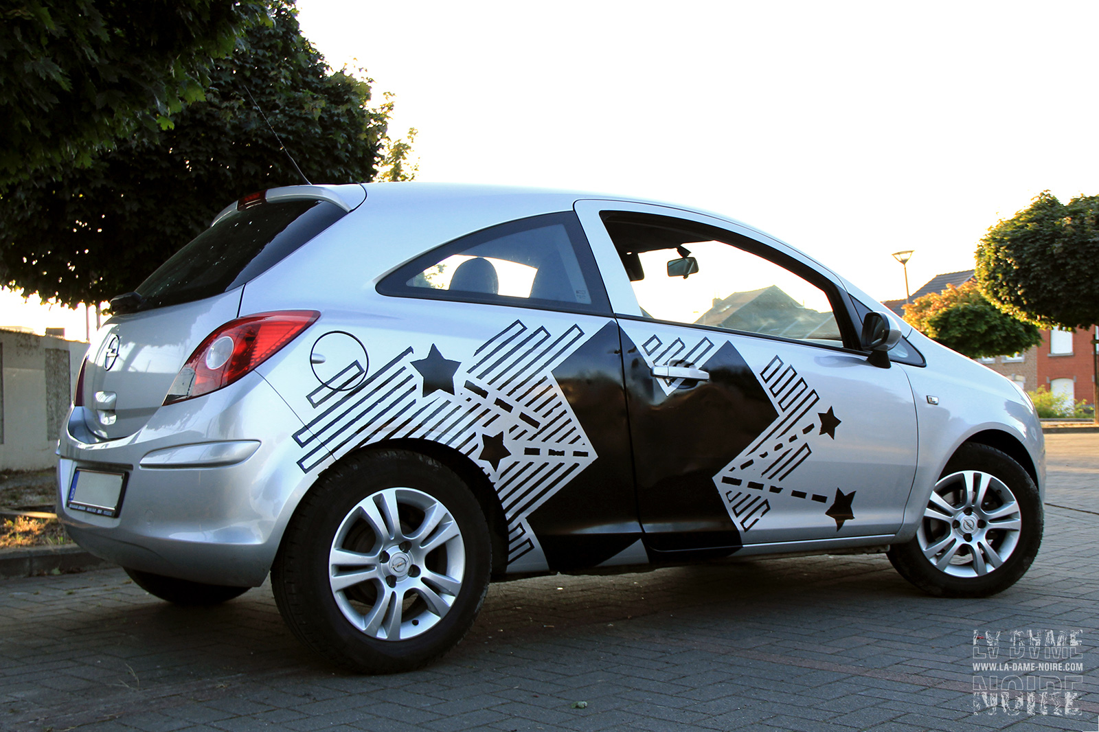 Right side of a car painted with stars and a big black cross